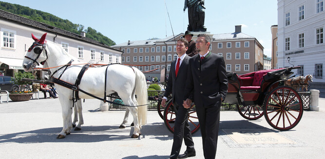 LGBT - Marriage in Salzburg, couple in front of horse carriage at Mozart monument | © Tourismus Salzburg GmbH