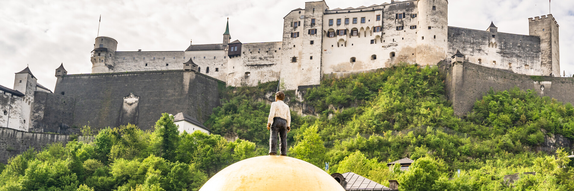 Couple walking at Kapitelplatz Square past the Sphaera towards Hohensalzburg Fortress | © Tourismus Salzburg GmbH / M. Kohlmayr