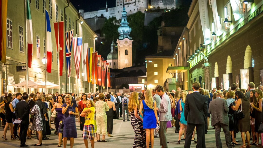 Festival guests in the Hofstallgasse in front of the Großes Festspielhaus | © Tourismus Salzburg / G. Breitegger