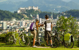 Two cyclists enjoy the view of the city of Salzburg | © SalzburgerLand Tourismus