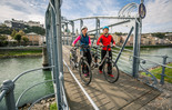 Couple pushes their bike over the Mozartsteg