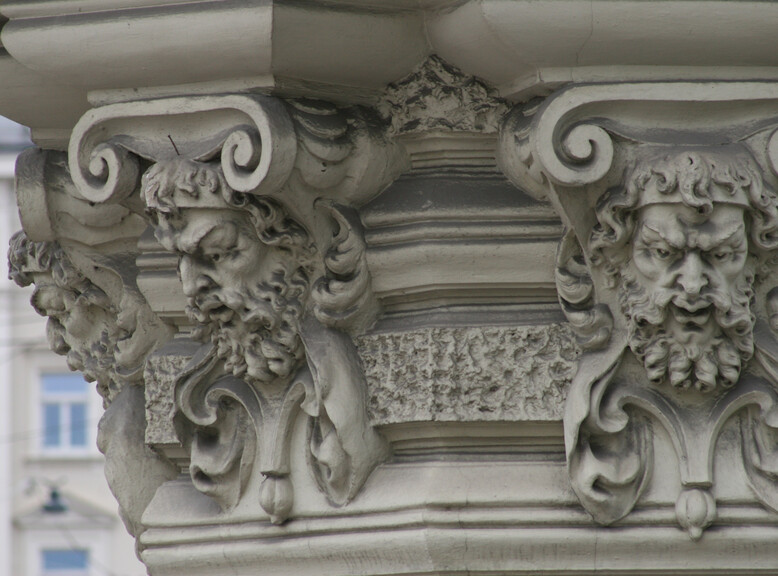 Verzierungen mit einem Kopf eines bärtigen Mannes an einem Gebäude | © Veronika Zangl