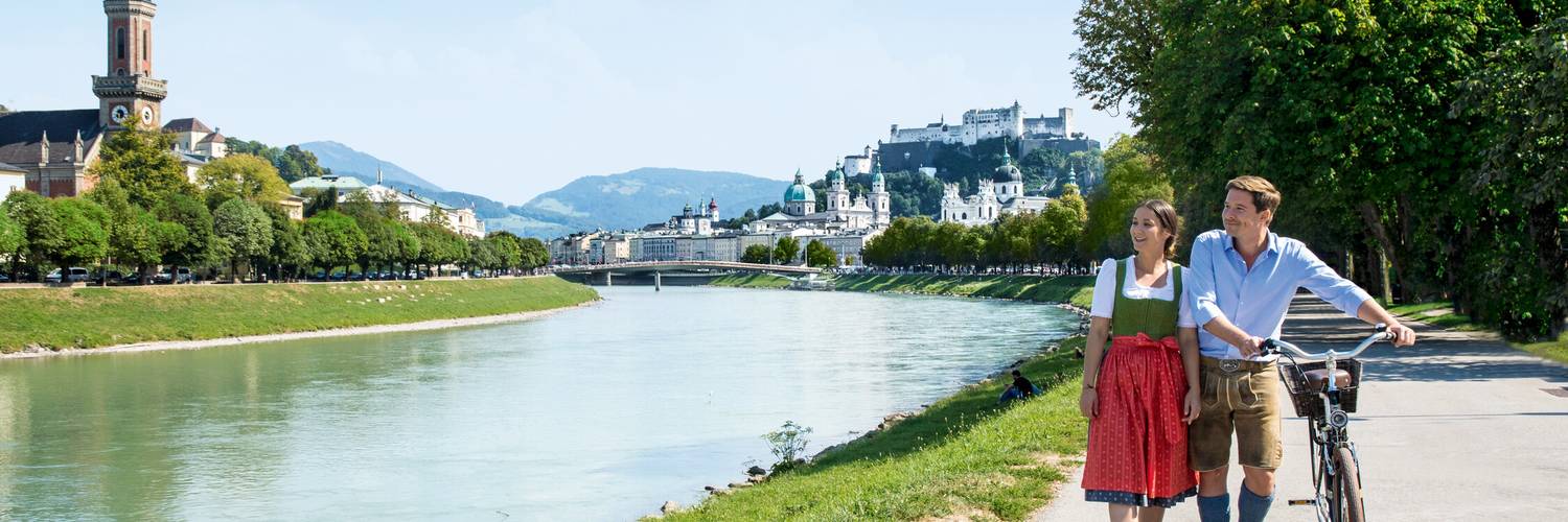Couple with bike at the Salzach | © Tourismus Salzburg