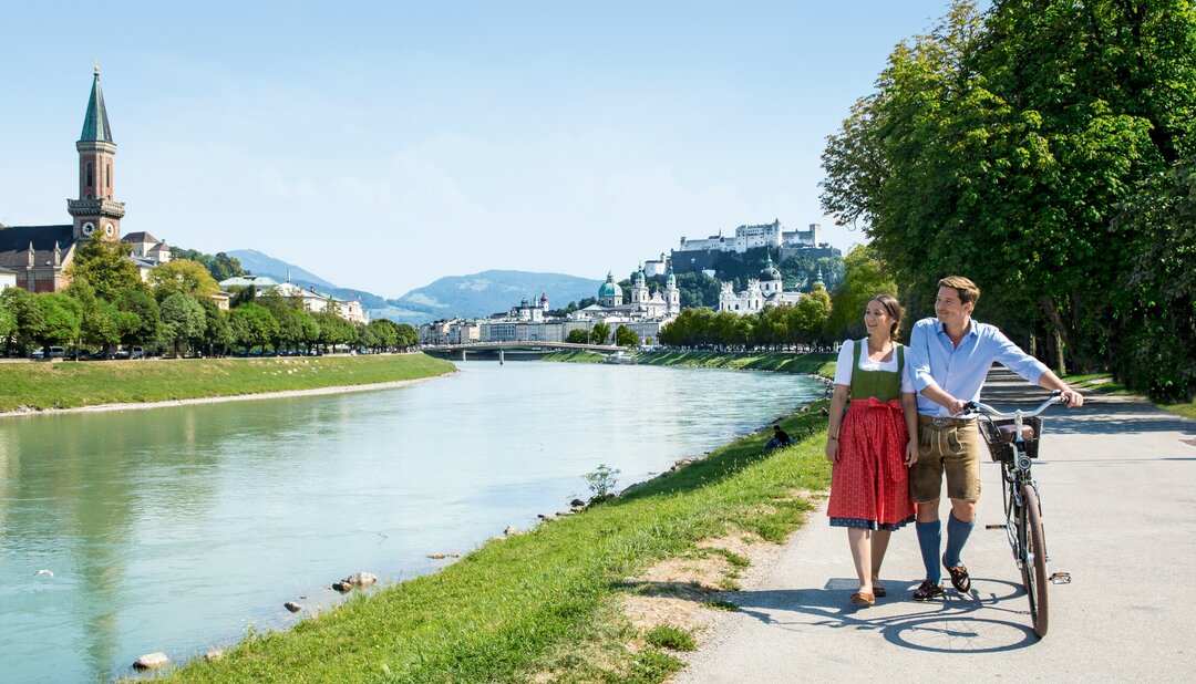 Couple with bike at the Salzach | © Tourismus Salzburg