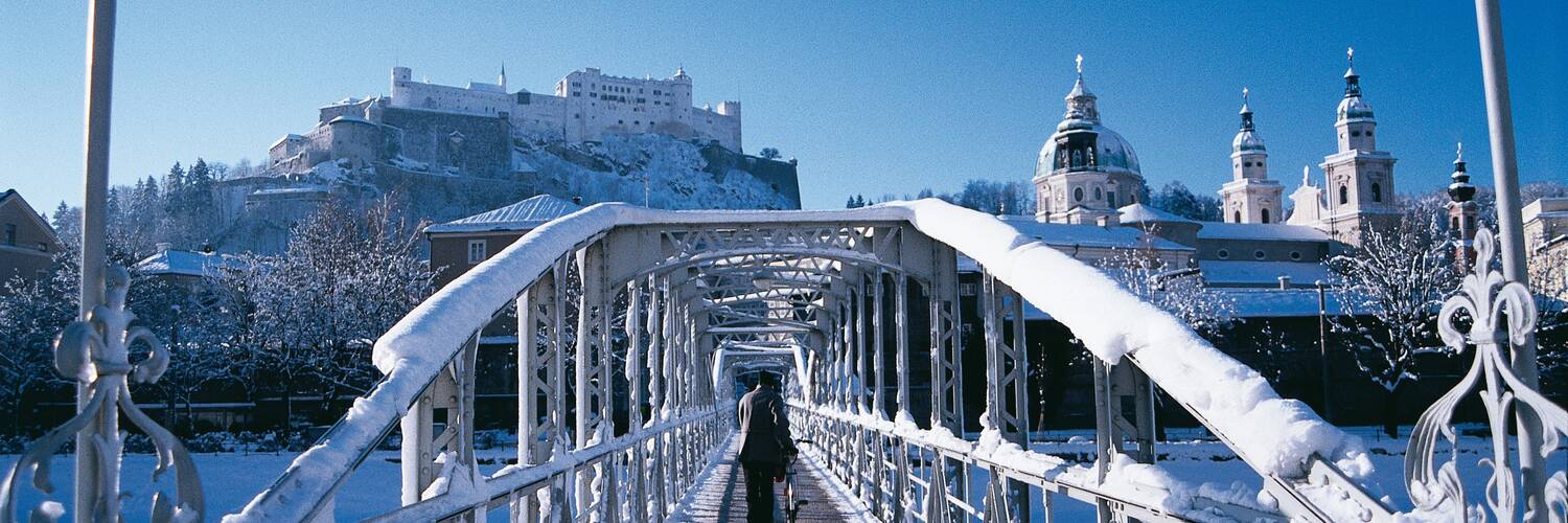 The Fortress Hohensalzburg viewed from a snowy Mozartsteg bridge | © Tourismus Salzburg GmbH